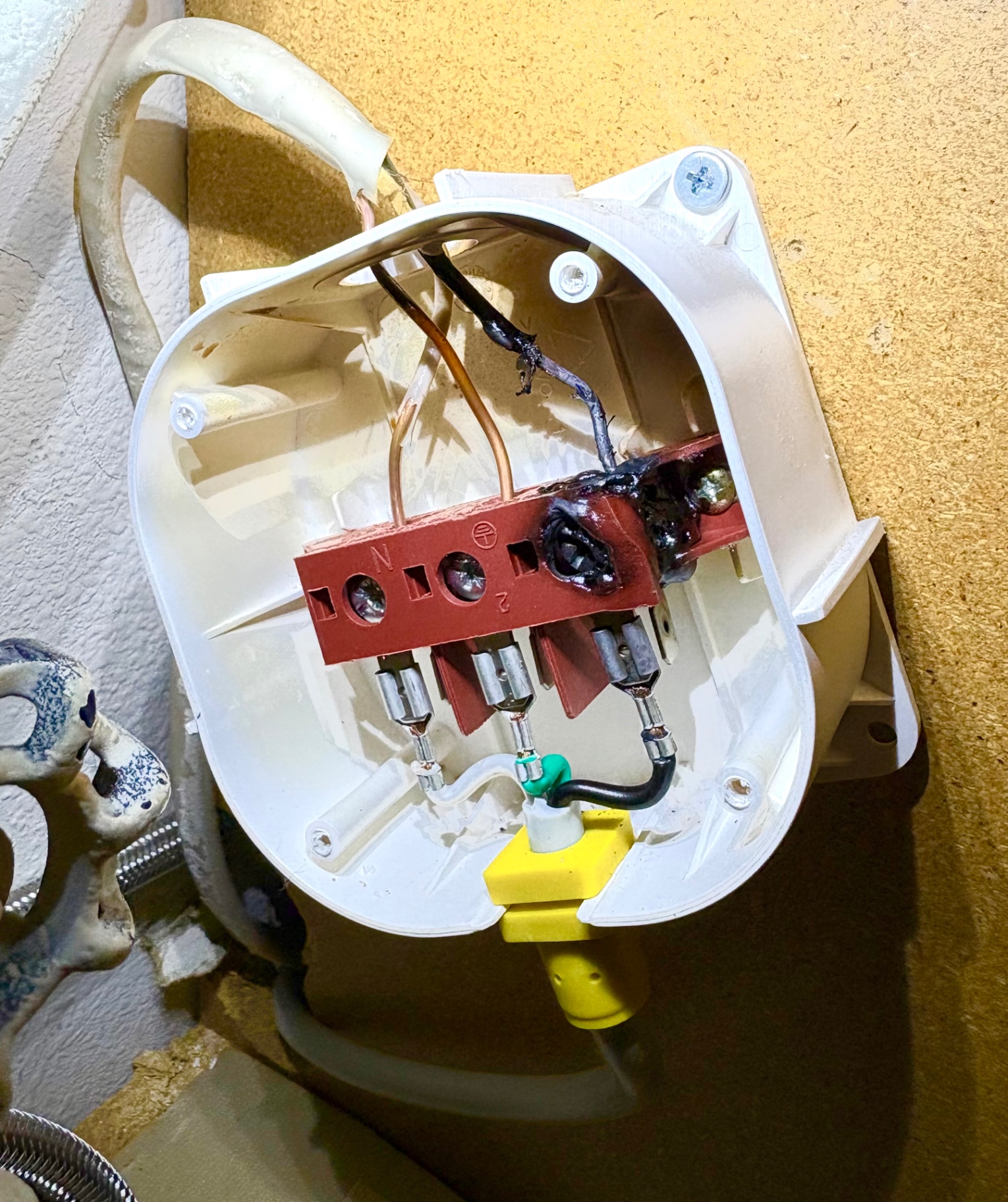 Burned electrical junction box that powered a dishwasher, with a melted and charred terminal and scorched wire insulation, documented during a Knapp's service call in the Portland area.
