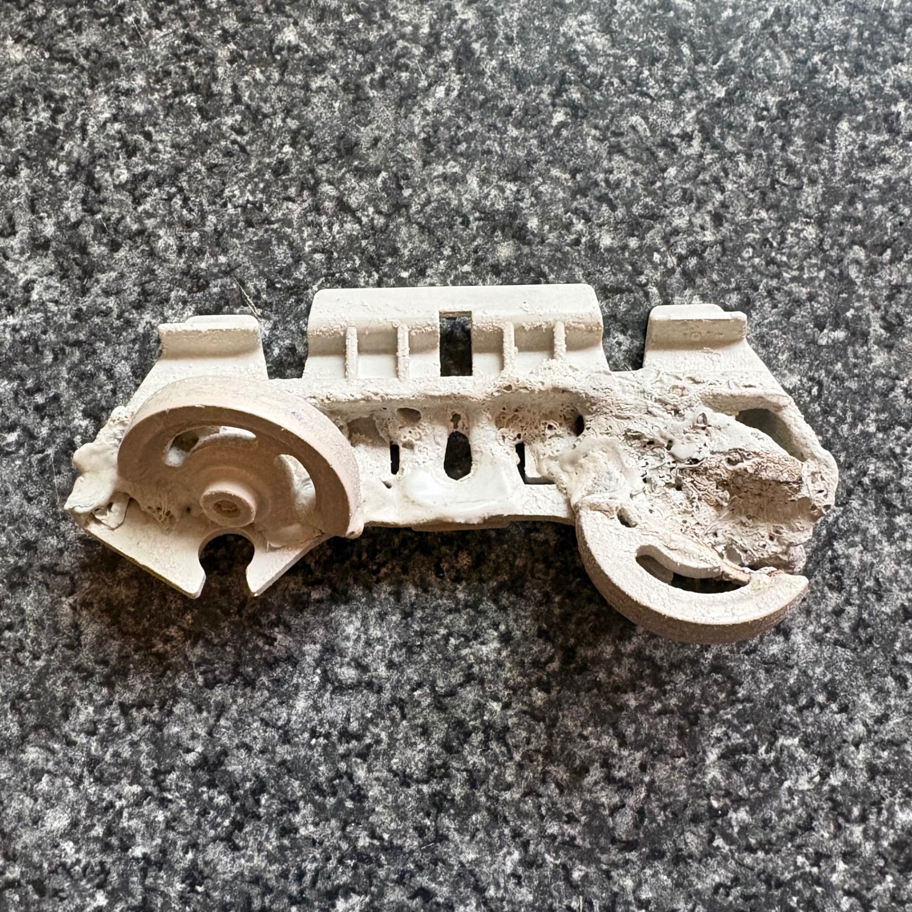Melted dishwasher dishrack wheel that fell onto the heating element, shown after removal during a Knapp's service call in the Portland area.